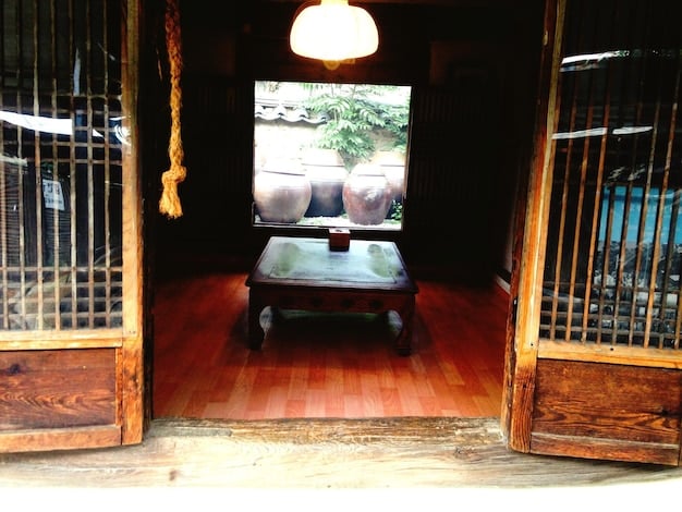 An indoor set of a Korean traditional house inside Jeonju Cinema Complex, with film crew equipment visible.
