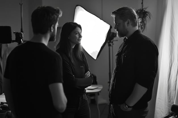 A black and white photograph capturing a casting director in a serious discussion with an actor during an audition for a Korean film. Focus on the intensity and focus in the room.