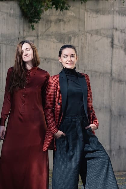 A scene from a Korean drama showcasing two female leads wearing contrasting yet trendy outfits. One is in a chic tailored suit with bold accessories, while the other is in a bohemian-inspired dress with layered jewelry. The overall aesthetic is polished and visually striking, reflecting the attention to detail in Korean drama fashion.